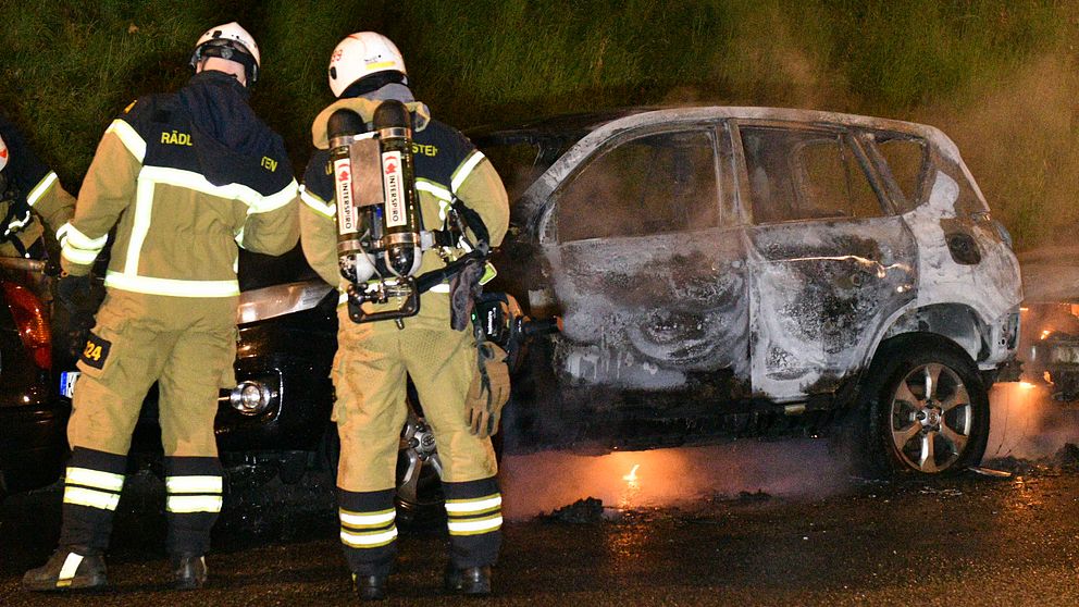 Polisen släcker ned en brinnande bil