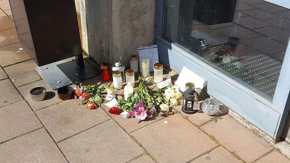 Blommor, ljus och skriftliga hälsningar på platsen där den hemlöse mannen mördades.