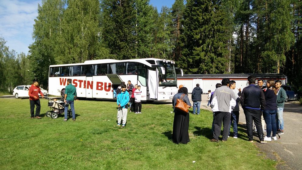 asylsökande i krokströmmen står utanför en buss