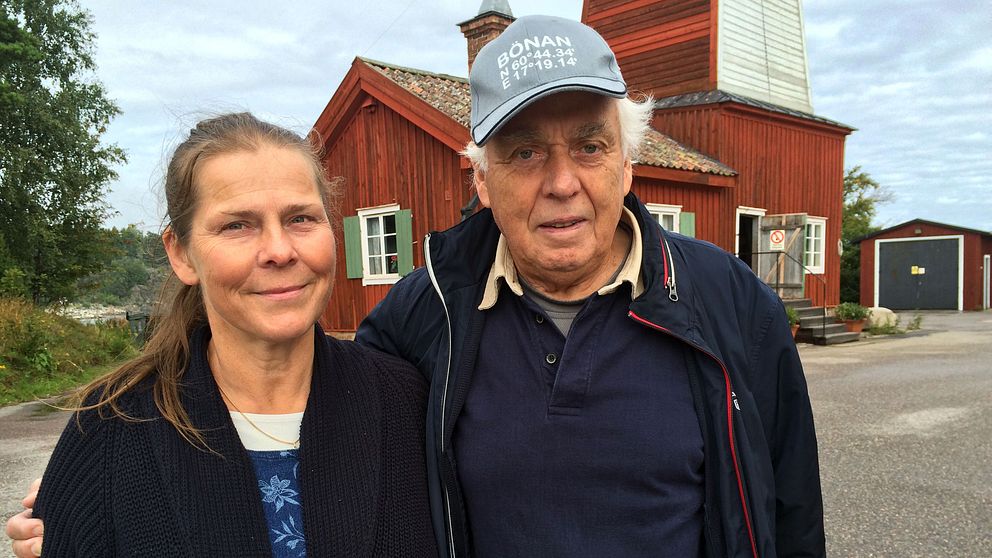 kvinna och man framför äldre träbyggnad