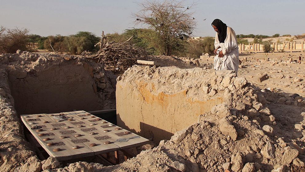 En man betraktar en av de förstörda historiska gravarna i Timbuktu i Mali.