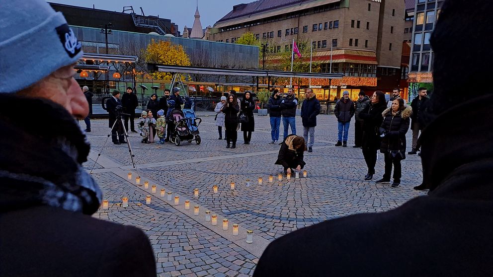 Människor står i ring på torgeti Södertälje