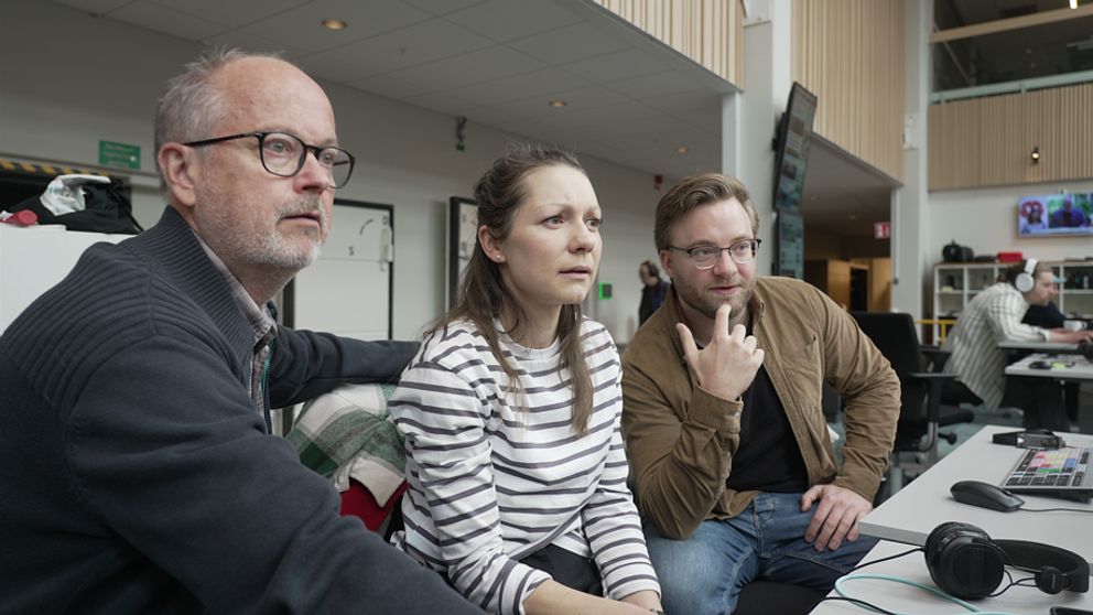Tre journalister från SVT:s Verifierings desk tittar på en datorskärm.
