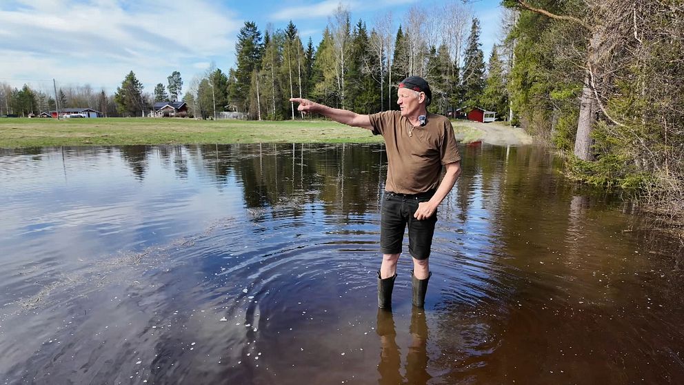 Man står i stövlar i vatten och pekar.