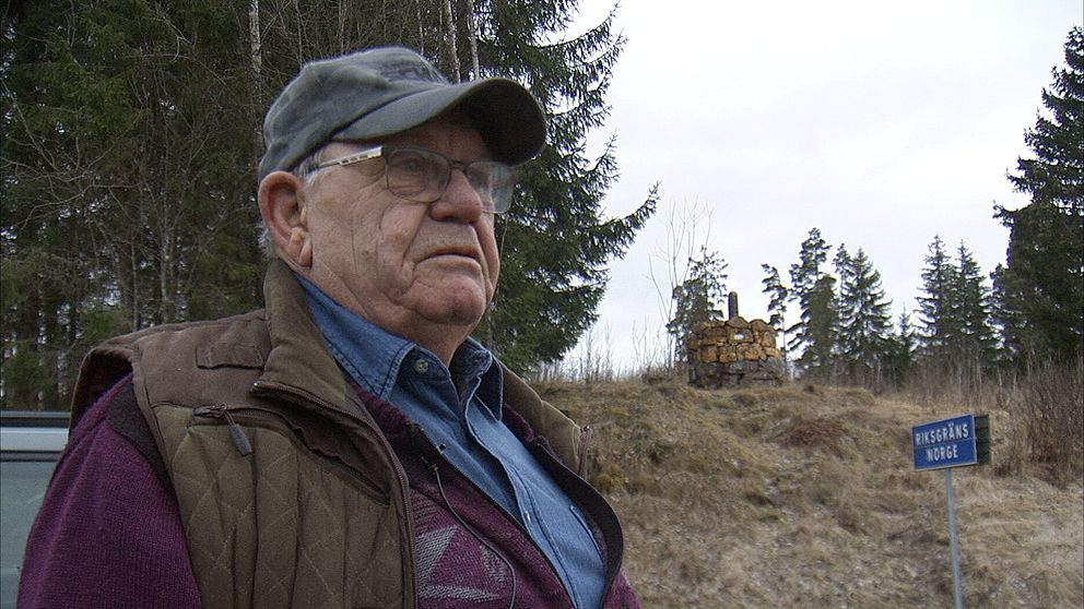 Mannens kropp framför en skog med ett grävmaskin i bakgrunden. Skogsskylt syns.