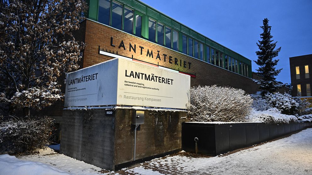 Lantmäteriets byggnad i vintrig miljö, med mörkblå himmel och snö på marken.