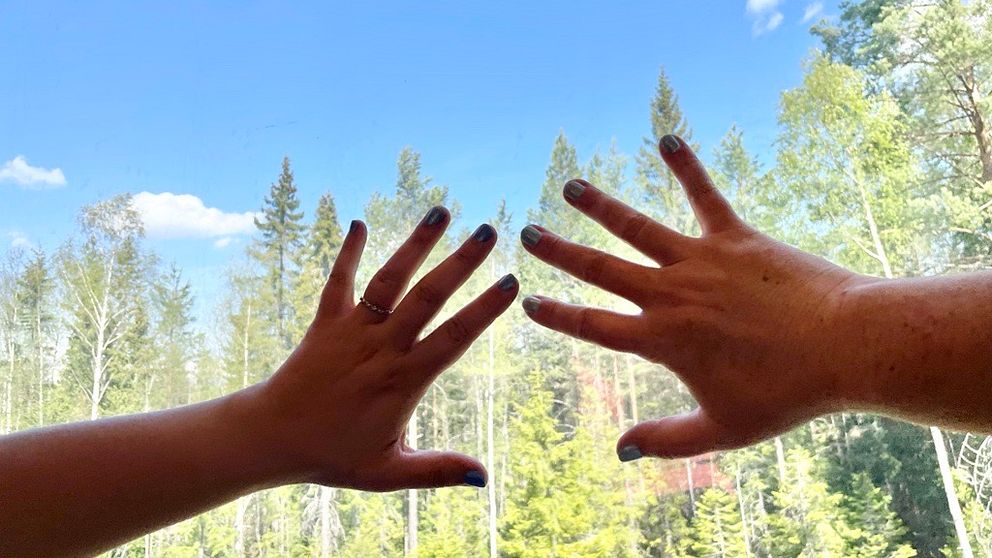 Två händer med naglarna målade i turkost