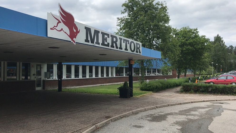 Entré till Meritor-fabrik med logotyp och omkringliggande grönska.