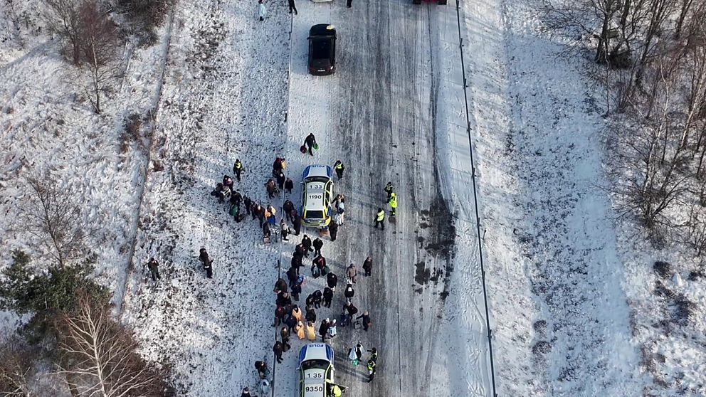 Människor står kring polisbilar på E18