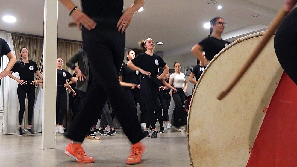 Fötter och människor på dansgolv med trumma i förgrunden