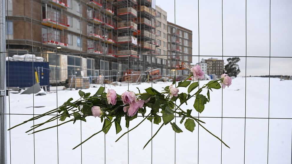 Blommor vid stängslet till arbetsplatsen i Sundbyberg där en bygghiss rasade