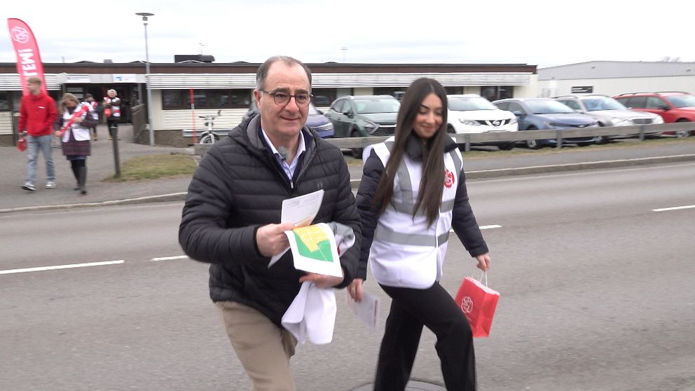 Ilan De Basso (S) och Melisa Alijeveska går över en väg med broschyrer i handen.