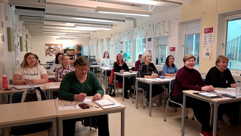 Ukrainare som sitter i ett klassrum och lär sig svenska språket.