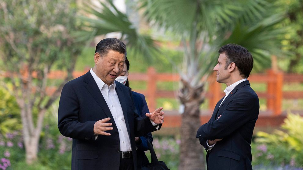 Xi Jinping med Emmanuel Macron. Två män pratar utomhus.