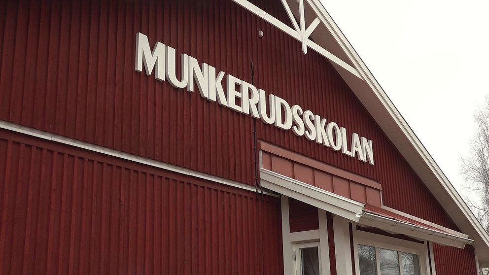 Röd skolbyggnad med skylten Munkerudsskolan ovanför entrén.