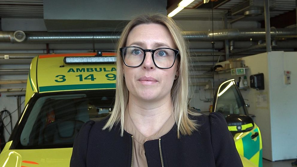 Verksamhetschef Lina Ideborg framför ambulans i garage
