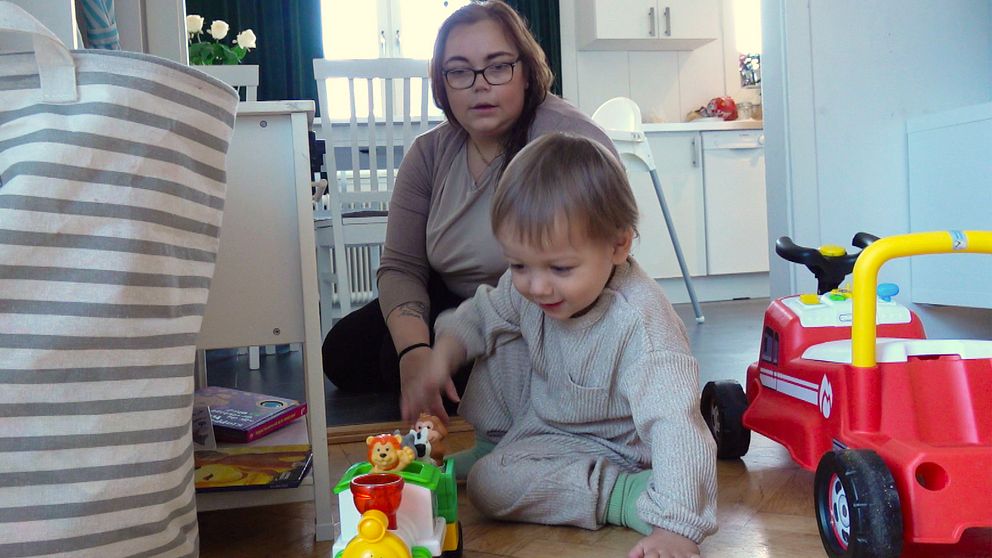 Föräldern Malin Åsells är kritisk mot nedläggningen av Karlavagnens dagverksamhet. Här leker hon med sonen Hannes på golvet.