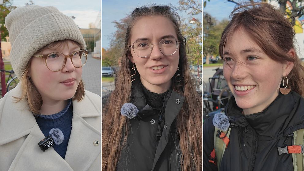 Tre personer är fotograferade utomhus, klädda i olika jackor och med mikrofoner fästa vid sina kläder. Den första personen bär en vit mössa och en ljus jacka, den andra har på sig en svart jacka med en mörk tröja under, och den tredje personen har en svart jacka med detaljer i grönt och guldörhängen. Bakgrunden visar en klar himmel och del av en stadsmiljö.