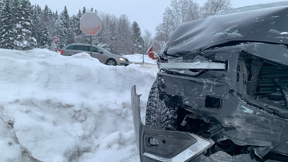 En bil som krockat står bredvid en snövall.