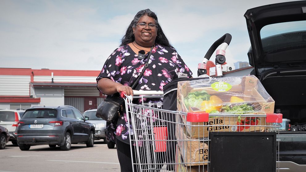 Kvinna med matvagn framför affär