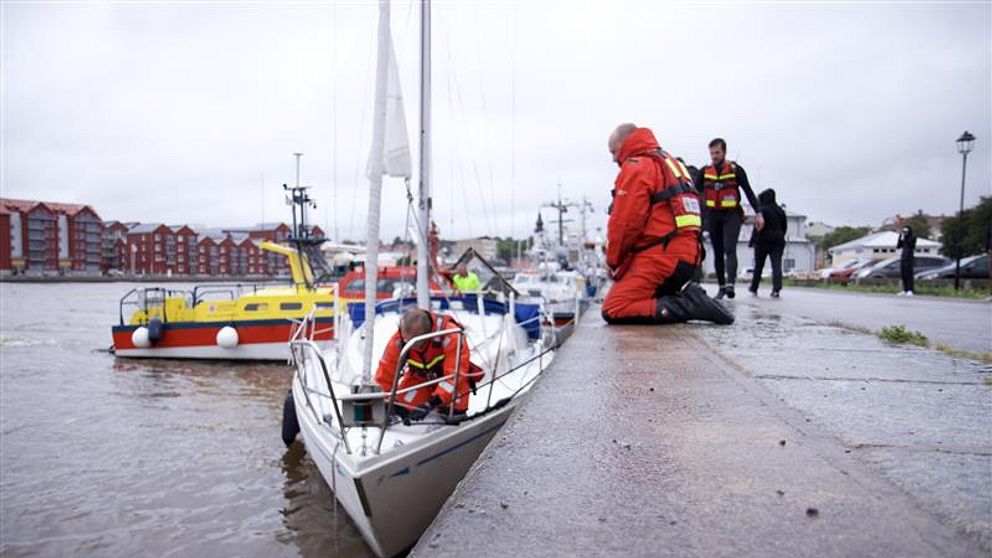 En segelbåt intill kajen i en småbåtshamn.