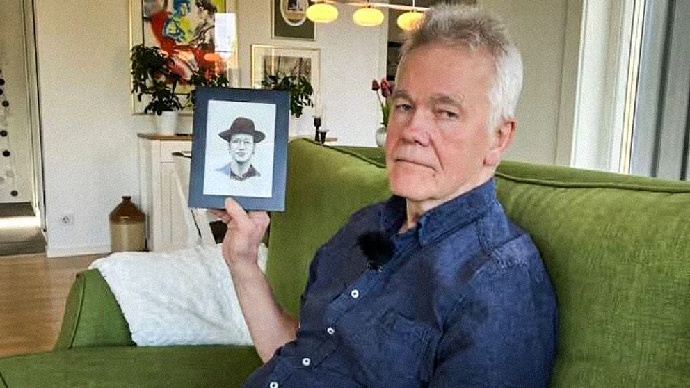 Ola Binis pappa, Dag Gustavsson, håller upp en karikatyr av sin son.