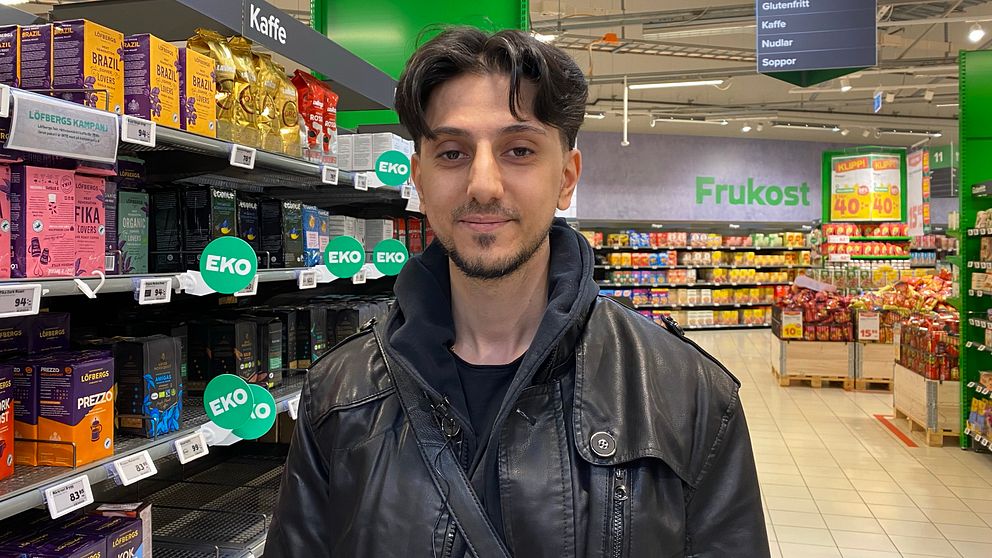 Person framför butikshylla med ekologiska produkter.
