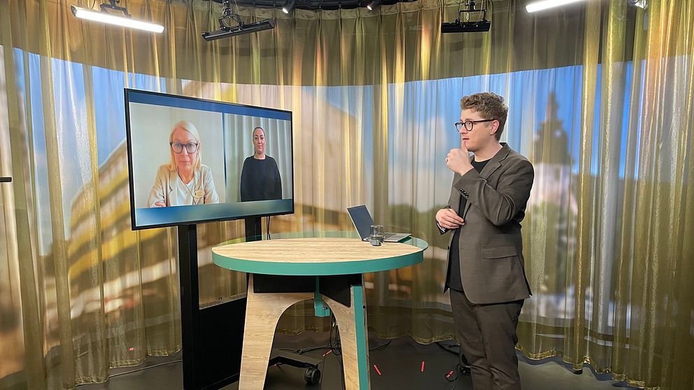 Magnus Bergevin står i en tv-studio. Zandra Ahkoila och en teckenspråkstolk syns på en skärm i ett videomöte.