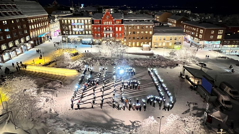 Människor med ficklampor har formerat sig i ordet ”hej” på stortorget i Östersund