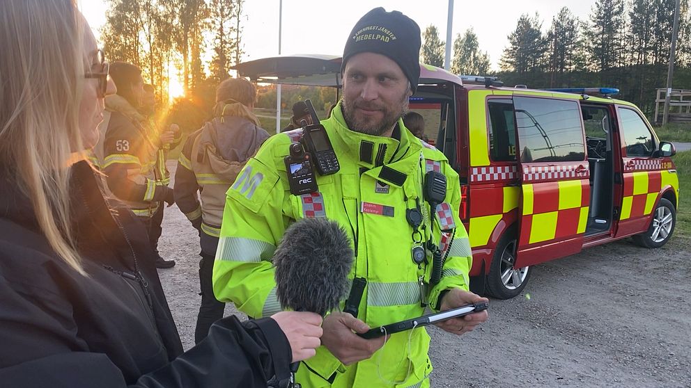 Brandman intervjuas intill ett område där en större gräsbrand utbrutit,