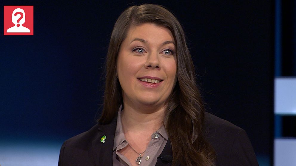 Miljöpartisten Elin Söderberg  iklädd en mörk kavaj med en grön partinål under en TV-sändning.