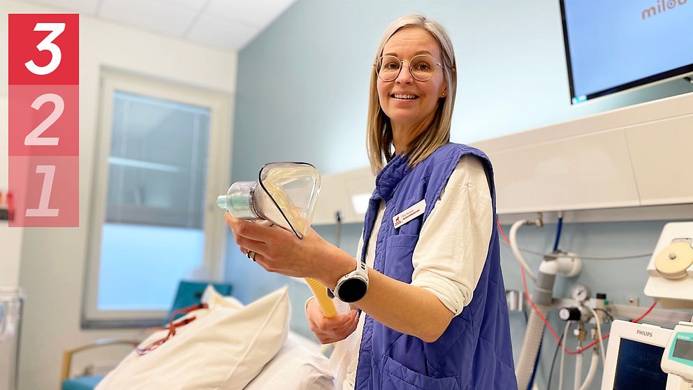 kvinna står i förlossningssal och visar en lustgas andningsmask
