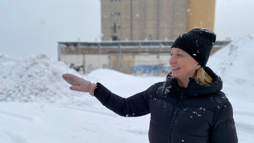 Kvinna står i snöyra och vevar med sin hand.