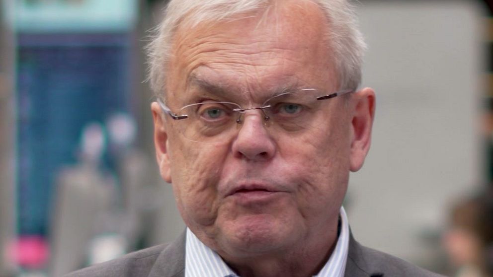 Man i kostym och skjorta intervjuas i en studiomiljö.