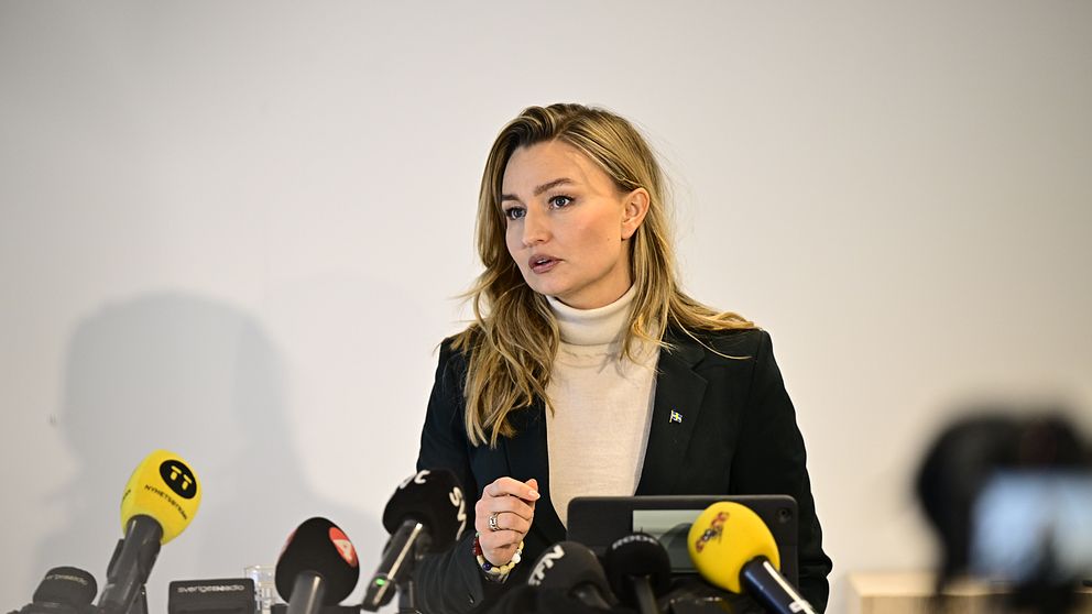 Ebba Busch talar vid presskonferens med flera mikrofoner framför sig.
