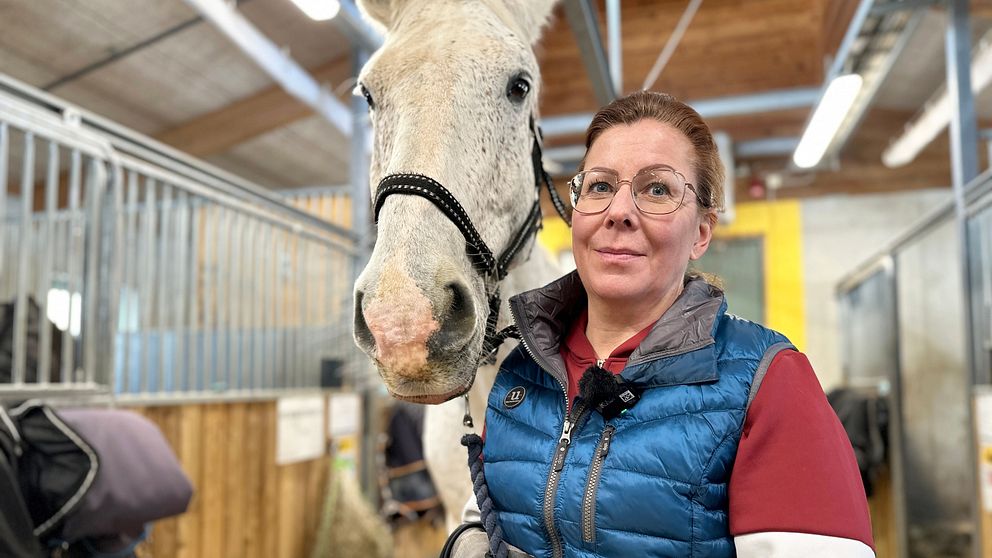 Verksamhetschef Camilla Granberg vid Umeå Ryttarförening håller i en vit häst