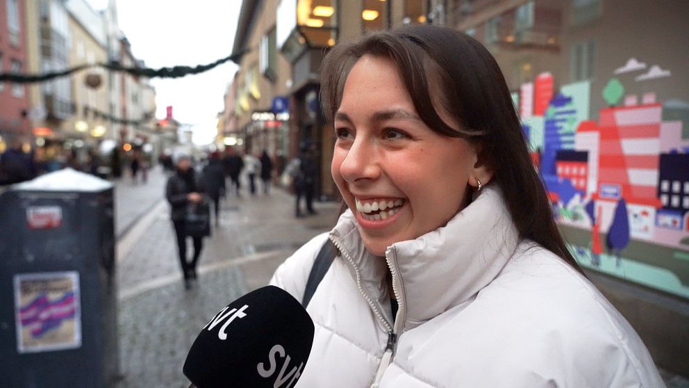Ung leende kvinna i dunjacka