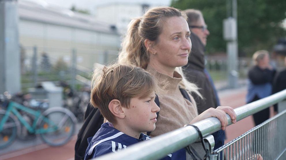 Fotbollsspelaren Ossian med sin mamma vid Mälarhöjdens IP som varit stängt efter dödsskjutningen. ”Jag tänker fortfarande komma hit för att spela”, säger Ossian Stridsman.