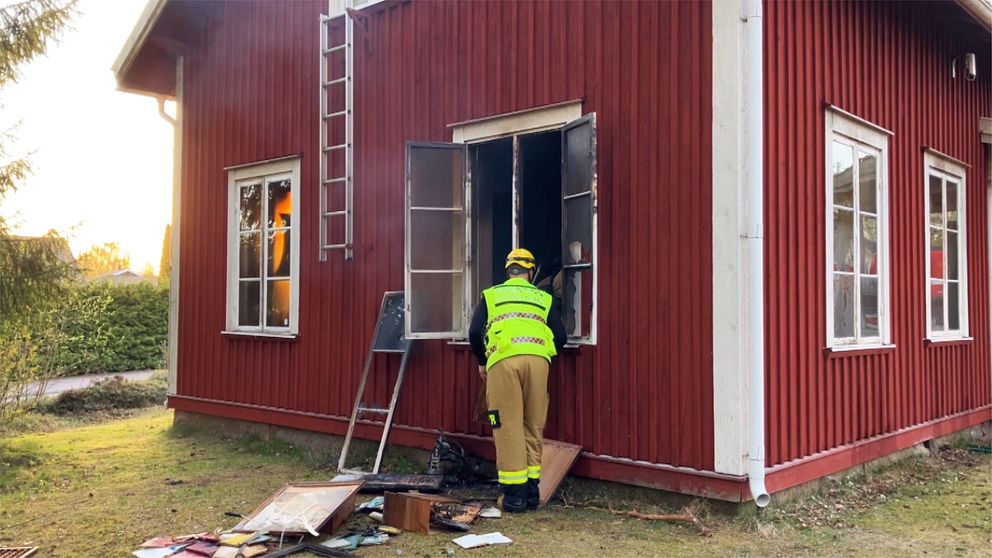 brand i rött hus med brandman
