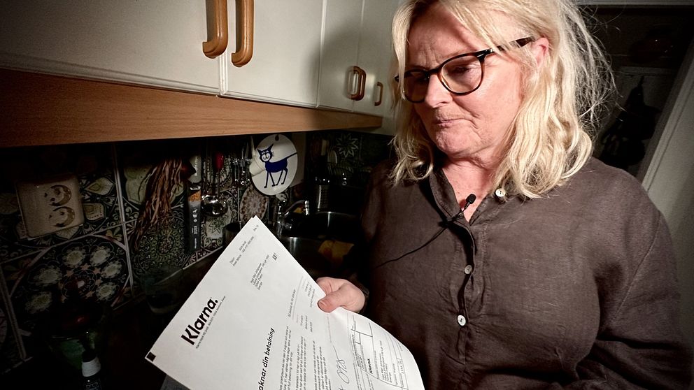 Marie håller upp fakturan från Klarna, där hon blandade ihop siffror i OCR-numret.