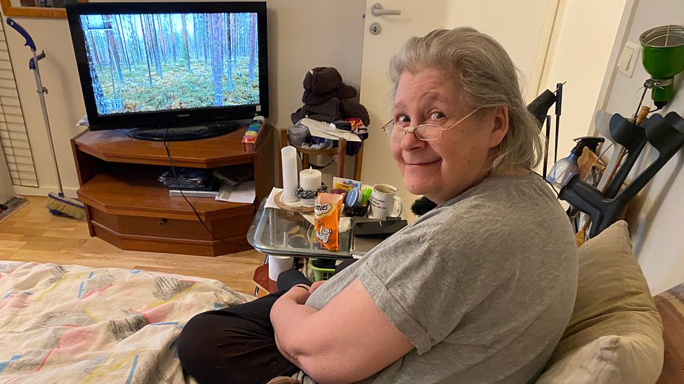 Ulla Malmgren sitter i sin säng och tittar på ”Den stora Älgvandringen”
