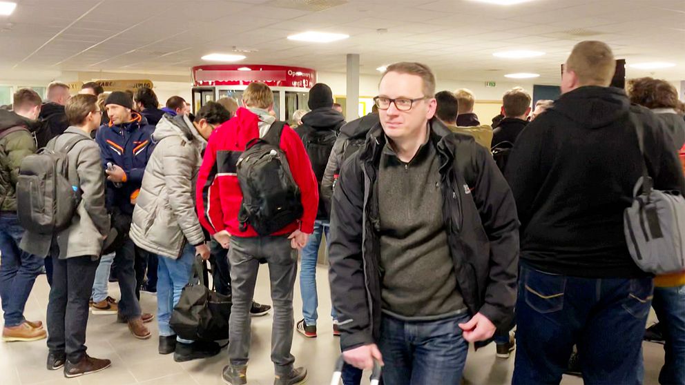 Personer i vinterkläder står och väntar på sitt bagage inne på Arvidsjaurs flygplats.