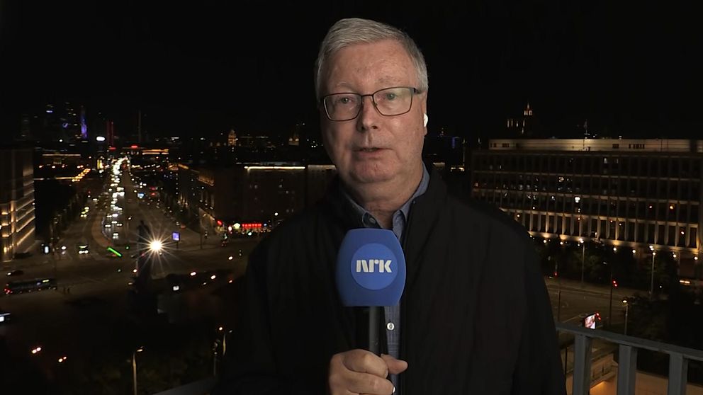 Jan Espen Kruse rapporterar för NRK med stadsmiljö i bakgrunden på kvällen.