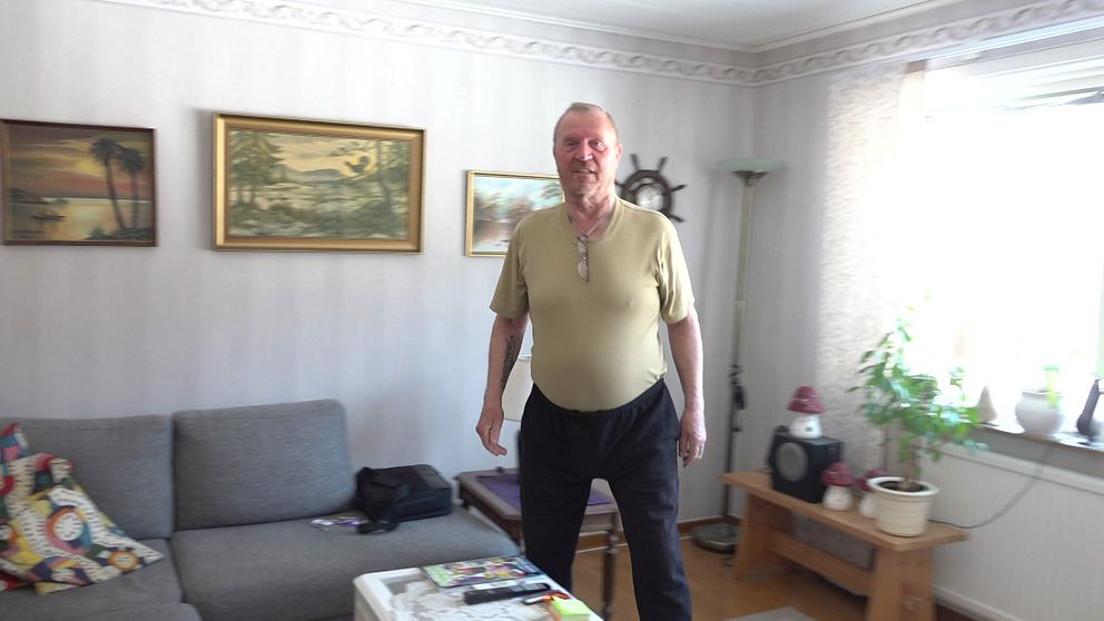 Tommy Broström står i sitt vardagsrum