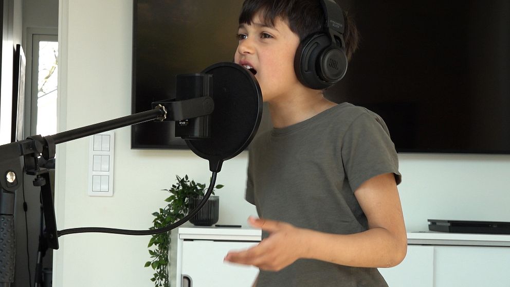 Pojke som sjunger i en mikrofon