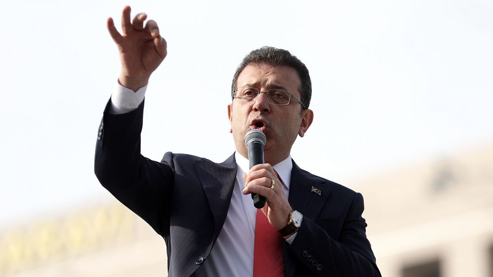 En bild på Ekrem Imamoglu när han talar i en mikrofon utomhus.