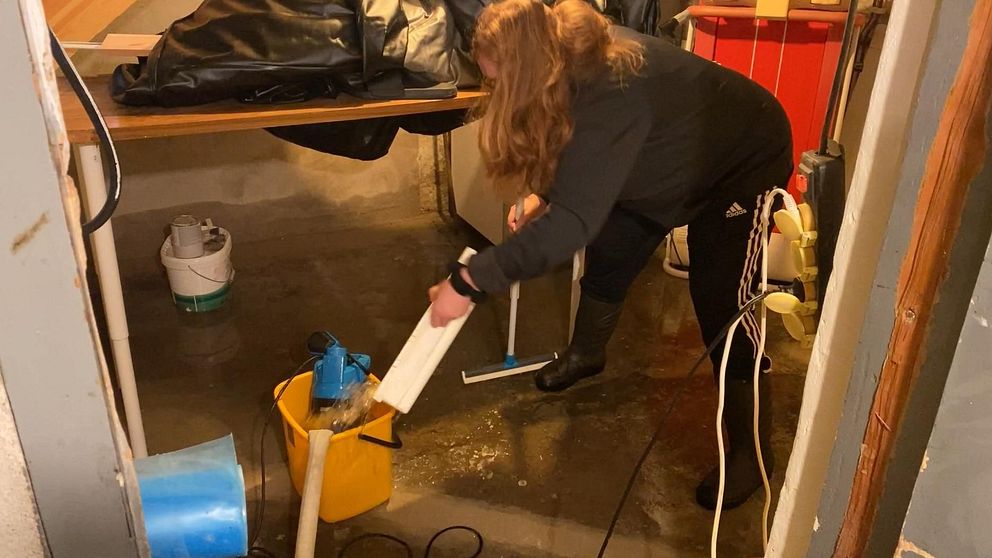 Ingrid Jernberg öser vatten från sin källare.