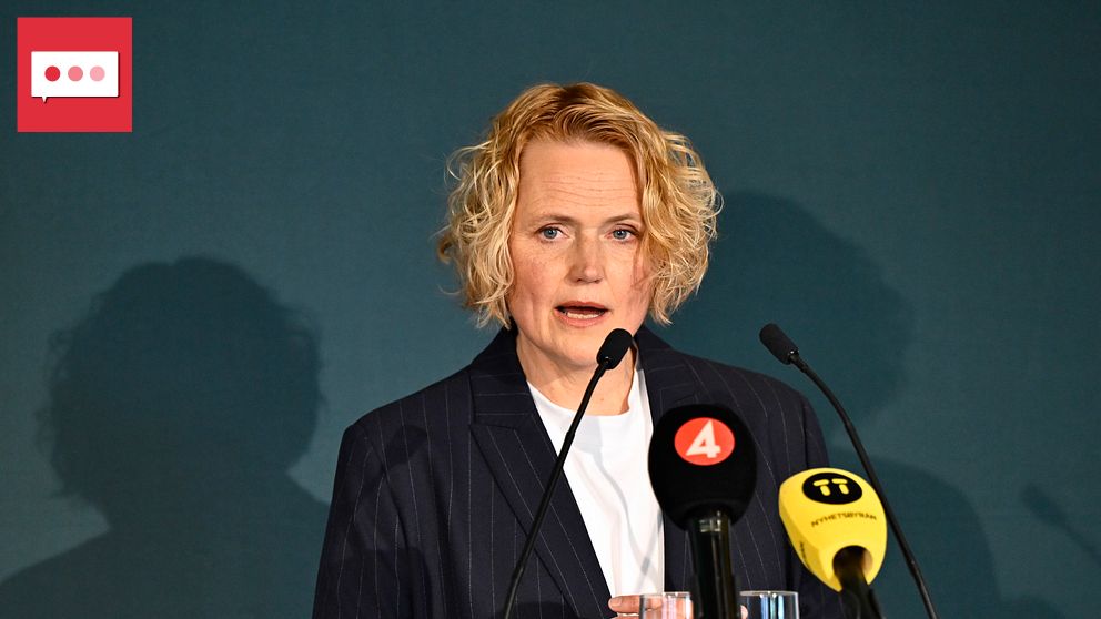 Person vid talarstol med mikrofoner och tv-mikrofoner från TV4 och SVT framför sig.