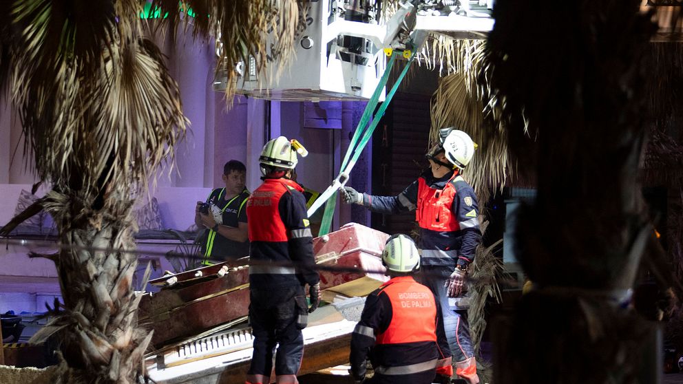 Fyra personer från räddningstjänsten framför en byggnad.