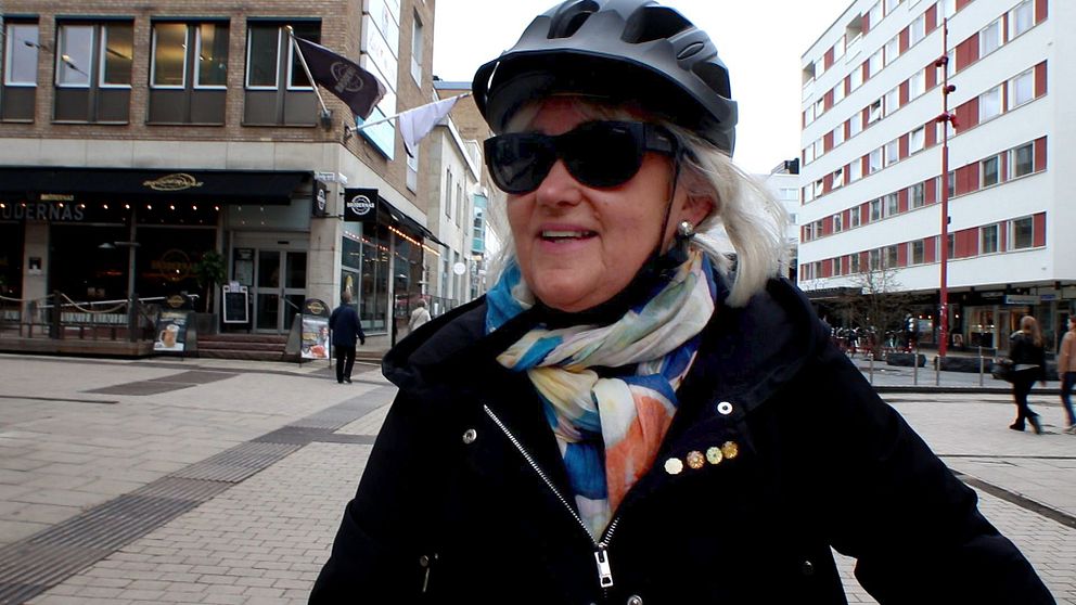 Kvinna med hjälm och solglasögon på stan.